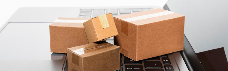 Shipping costs - Responsibility for returning defective products Cardboard boxes on a laptop, representing shipping costs for returning products