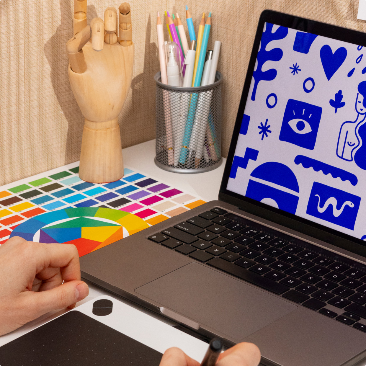 Laptop and colour swatches used to prepare artwork files for apparel printing